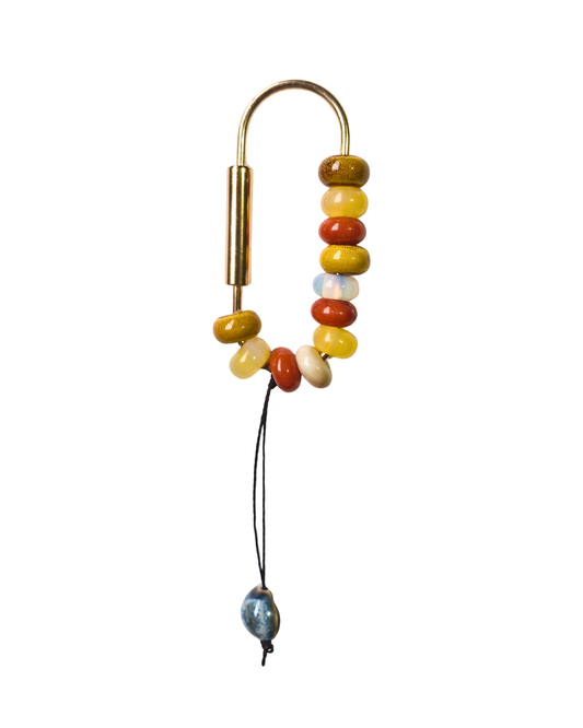 Detalle de cuentas de ópalo, jade y cuarzo en bag charm hecho a mano.