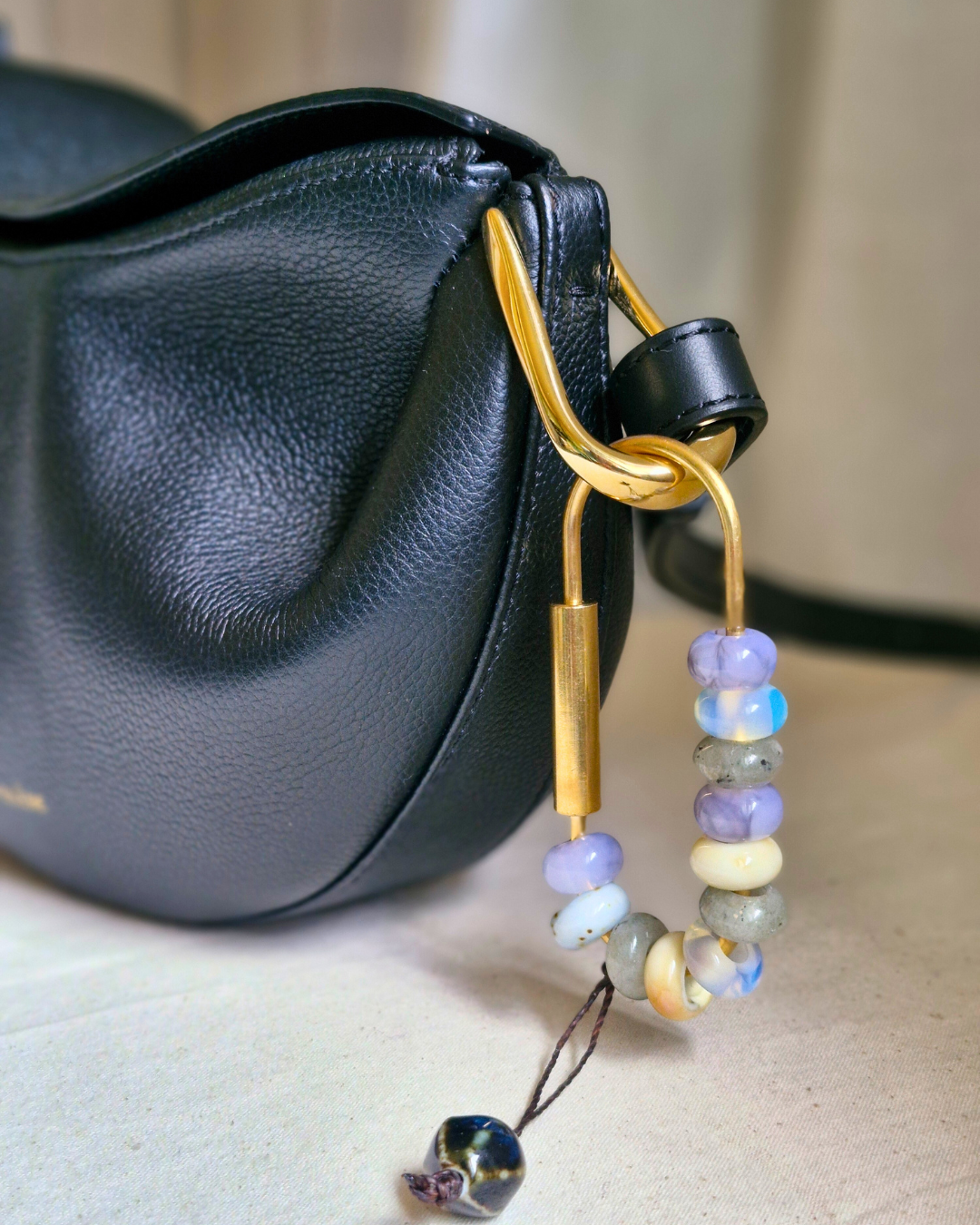 Bag charm artesanal con piedras naturales ópalo, jade y cuarzo colgando de bolso