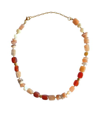Detalle del collar Reflets d'Aube mostrando la combinación de ágata roja, concha y piedra solar.
